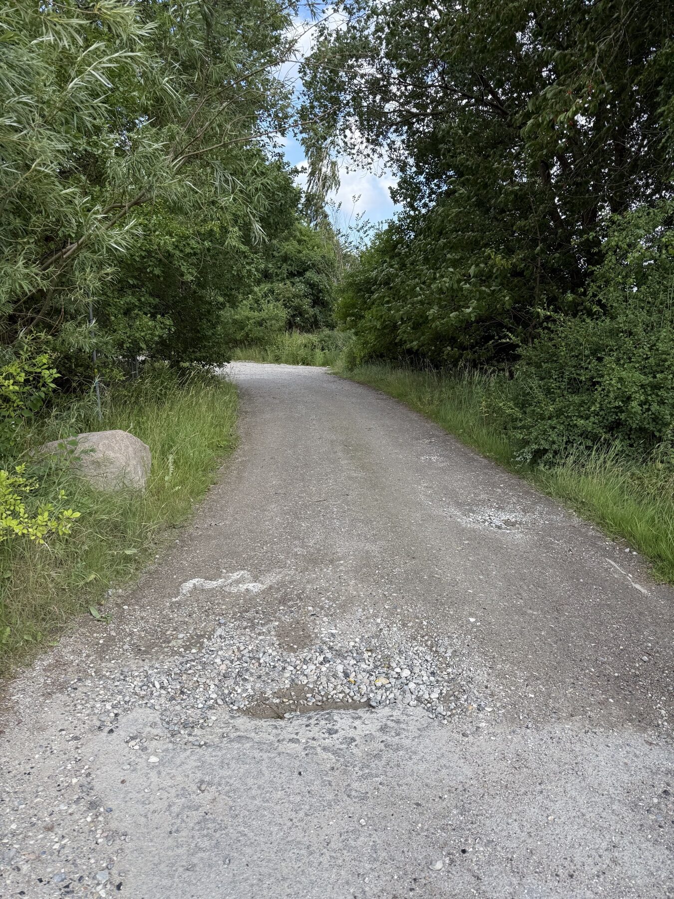 Grusareal set fra indkørslen med låge