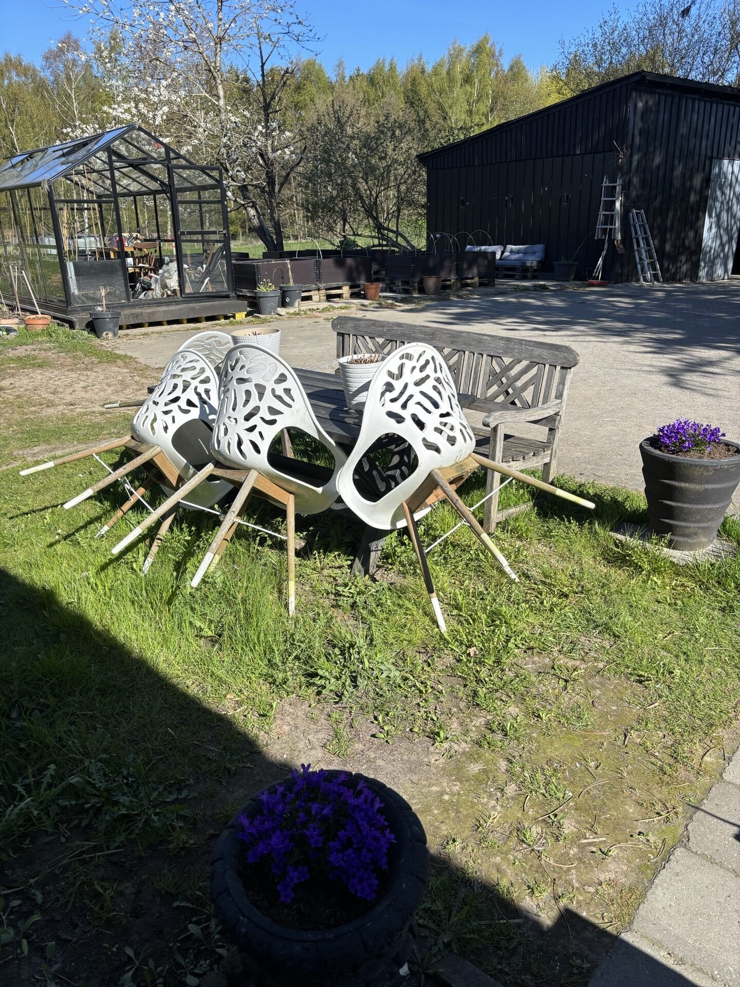 Gårdhave med havemøbler og blomsterpotter ved stråtagshuset