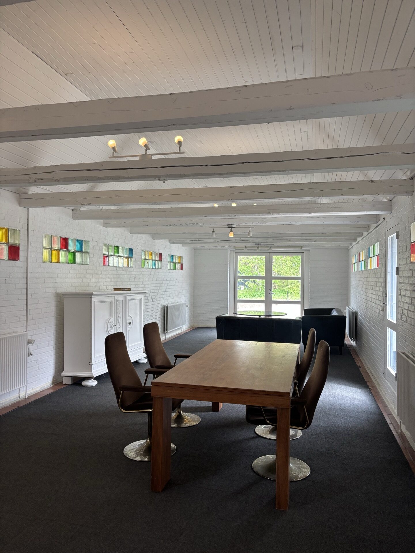 Spisebord med stole ved vindue i husets lange stue